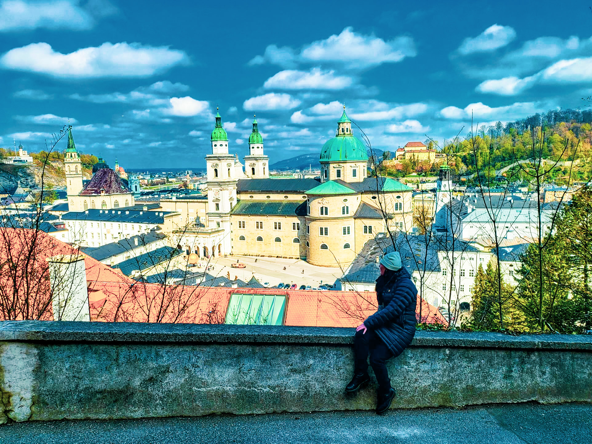 Lauren Robinson enjoying a scenic view of Salzburg’s rooftops from a balcony, capturing the city's historical charm